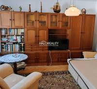 Living room in a 3-room apartment with wooden furniture and a floor with a wood design.