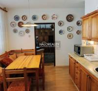 A kitchen in a 3-room apartment with a wall decorated with plates and a floor with a wooden decor.