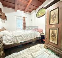 Interior of a cabin with a bed, decorated wardrobe, and floor with wooden decor.
