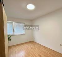 An empty room in a 4-room apartment with a wood-patterned floor and a built-in wardrobe.
