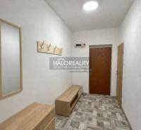 A hallway in a 4-room apartment with tiles and wooden furniture.