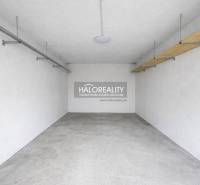 A garage space with white walls and a concrete floor, suitable for parking.