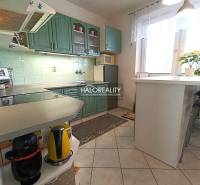 A kitchen in a family house with a bar counter, green cabinets, and decorations.