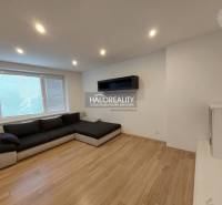 Living room in a two-room apartment with a corner sofa and a wooden decor floor.