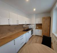 A kitchen in a 2-room apartment with a dining table and a wooden decor floor.