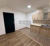 A studio apartment with a kitchen and a wooden decor floor, ideal for cozy living.