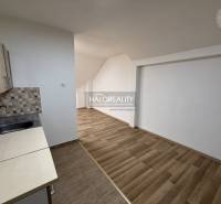 Studio apartment with a kitchenette and a wooden decor floor.