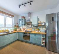 A spacious kitchen with light blue cabinets and stainless steel appliances in a 3-room apartment.