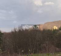 The landscape in Ladomerská Vieska with a view of wooded hills and an old castle.