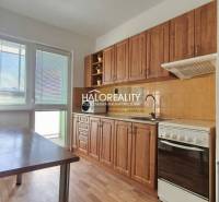 A kitchen in a 3-room apartment with a wooden decor floor, light walls, and a balcony.