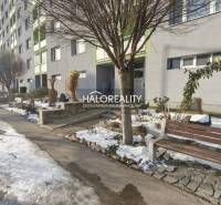 Apartment building with a snowy sidewalk and bench in Žiar nad Hronom near a 3-room apartment.