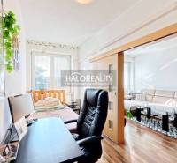 A workspace with a black chair and a desk, floor with wood decor.