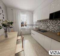A kitchen in a 2-room apartment with a wooden decor and flowers in a glass vase.