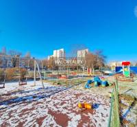 A children's playground with a slide in a snowy area in Petržalka, Bratislava.