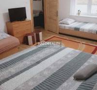 Interior of a family house with beds, a television, and a floor with a wooden decor.