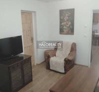 Living room of a family house with a television, an armchair, and a wooden decor floor.