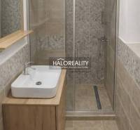 Bathroom in a family house with a sink, shower corner, and tiles with a wooden decor.