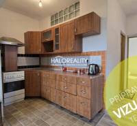 A kitchen in a family house with wooden decor cabinets and tiled flooring.