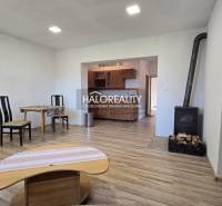Interior of a family house with a stove, wooden decor flooring, and simple furniture.
