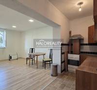 A kitchen with a wooden decor floor and a dining area in a family house.
