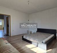A bedroom in a family house with a bed and a wooden decor floor.