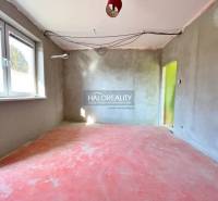 Interior of a family house under construction with a concrete floor and plastered walls.