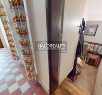 The hallway of a family house with a tiled floor and a staircase.