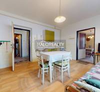 Dining room in a family house with a wooden decor floor and white furniture.