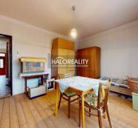 Dining room in a family house with a wooden decor floor and simple furniture.