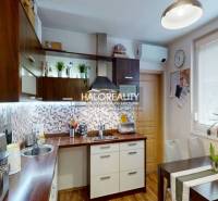 A kitchen with a dining table in a 2-room apartment with a wooden decor floor.