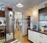 Kitchen of a 2-room apartment with a stainless steel refrigerator and wood-patterned flooring.