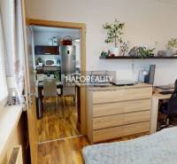 A room in a 2-room apartment with a wooden decor floor and a desk.