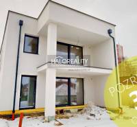 A modern two-story building with balconies in the snowy streets of Poprad, ideal for offices.