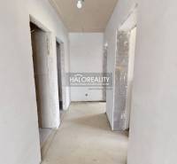 A hallway in an office with unfinished walls and floor, suitable for interior renovation.