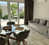 Recreational apartment with wood-patterned flooring, glass table, and sofa.