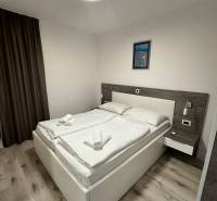 Bedroom with a large bed, curtains, and a wooden decor floor in a Holiday Apartment.
