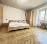 Bedroom with a bed and wardrobes in a family house with a wooden decor floor.