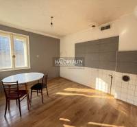 A family house kitchen with a round table and a wooden decor floor.