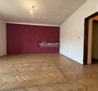 A room in a family house with a wooden decor floor and a purple wall.