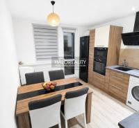 A kitchen in a 3-room apartment with a wooden decor floor and modern furnishings.