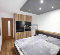 A bedroom with a wood-patterned floor and a built-in wardrobe in a 3-room apartment.