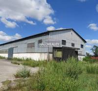 Warehouses and halls in Hurbanova Ves with metal structures and lush vegetation.