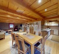 Interior of a cottage with a spacious kitchen, dining table, and floor with wood decor.