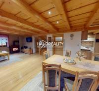 The interior of a cabin with a wood-patterned floor, a fireplace, and a comfortable sofa.