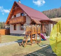 A cottage in Jezersko with a garden, wooden elements, and a children's playground on a sunny plot.