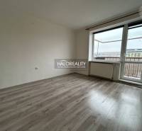 A room in a 2-room apartment with a wooden decor floor and a balcony.
