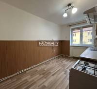 A kitchen with a wood-patterned floor in a 2-room apartment, a bright space with a window.