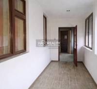 A hallway in a family house with a wooden decor floor and large windows.