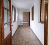 A hallway with light walls and a wooden decor floor in a family house.