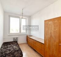 A room in a 2-room apartment with a wooden decor floor and simple furniture.